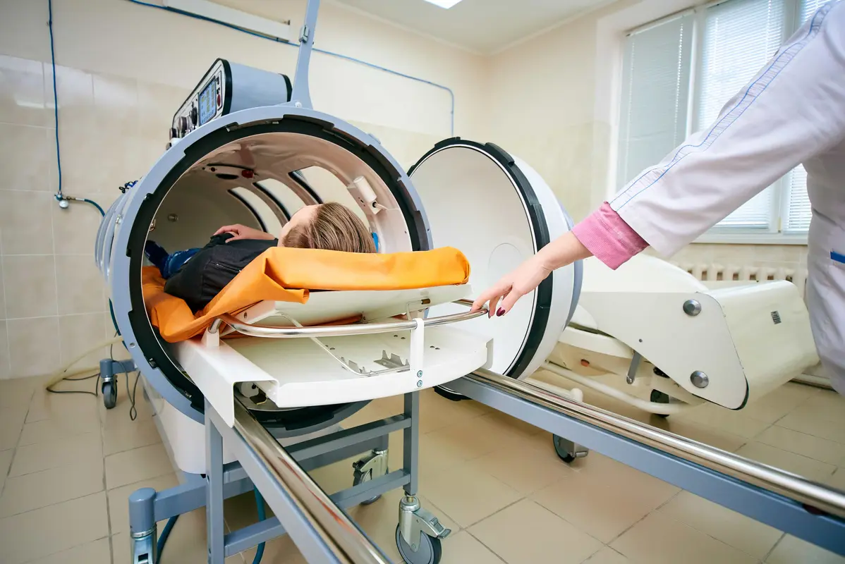 Patient receiving hyperbaric oxygen therapy inside a pressurized chamber for post-surgery recovery